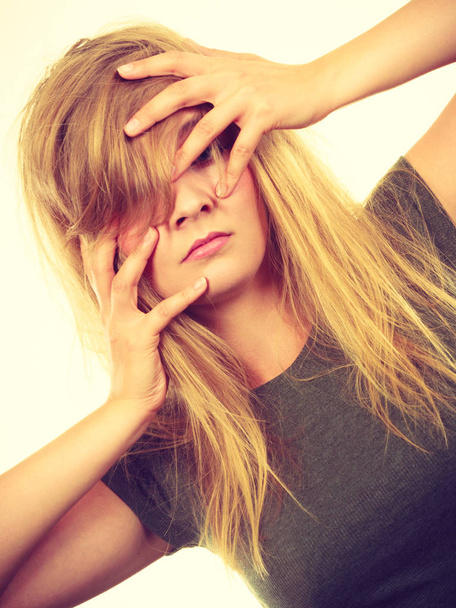 Ashamed embarrassed blonde woman with hands on face - Foto, afbeelding