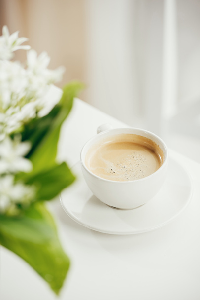 чашка кави з букетом квітів на стільниці
 - Фото, зображення