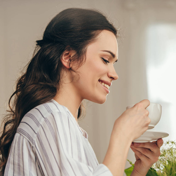 smiling woman drinking coffee at home - Photo, Image