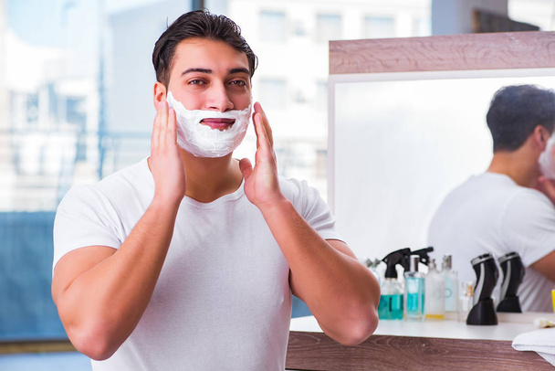 Young handsome man shaving in the morning - Photo, Image
