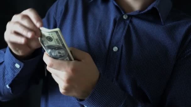 joven hombre de negocios cuenta billetes de cien dólares - Imágenes, Vídeo