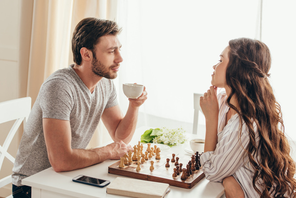 pareja joven jugando ajedrez en casa
 - Foto, Imagen