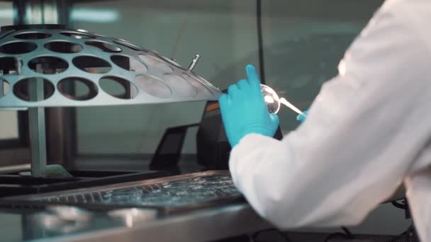 Ingenieur schoonmaken lens met wattenstaafje op fabricage metalen Bureau - Video