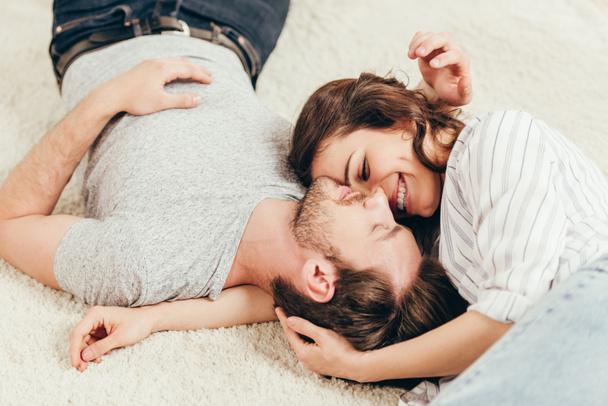 Jeune couple couché sur le tapis à la maison
 - Photo, image