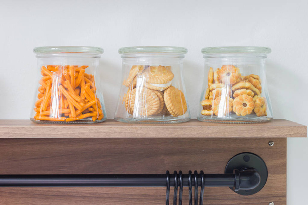 galletas saladas en botella de vidrio en estante de madera
 - Foto, Imagen