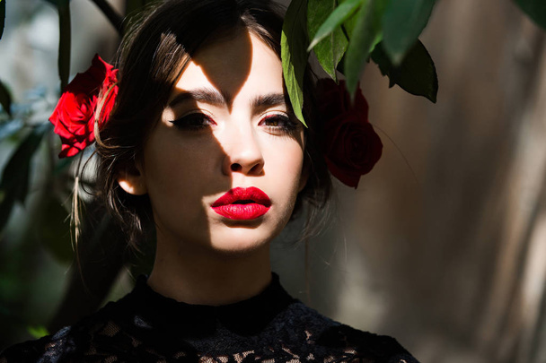 girl with red lips and roses in brunette hair - Fotoğraf, Görsel