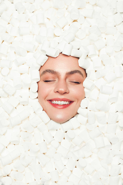 Content woman in marshmallows - 写真・画像