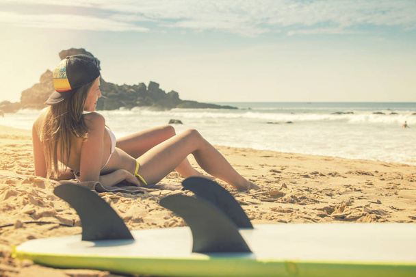 Surfer meisje liggend op het strand en kijken naar de Oceaan. Praia  - Foto, afbeelding