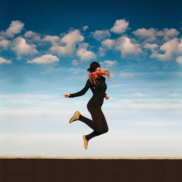 Щаслива дівчина стрибає на даху в сонячний день
 - Фото, зображення