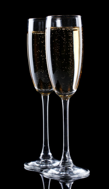 twee glazen champagne op zwarte achtergrond - Foto, afbeelding
