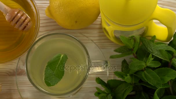 Имбирный чай с лимоном, мятой и медом на деревянном фоне
. - Кадры, видео