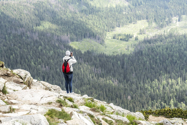 Woman photographer taking photo at mountain peak. - Fotoğraf, Görsel