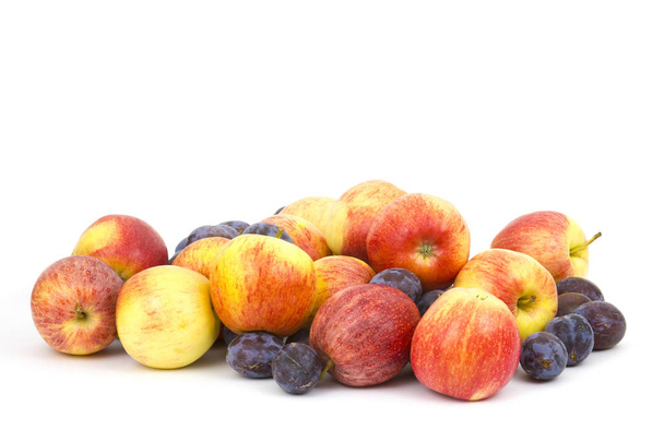 verse appels en pruimen op witte achtergrond - Foto, afbeelding