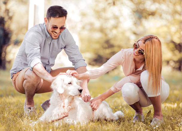 ラブラドル ・ レトリーバー犬と幸せなカップル - 写真・画像