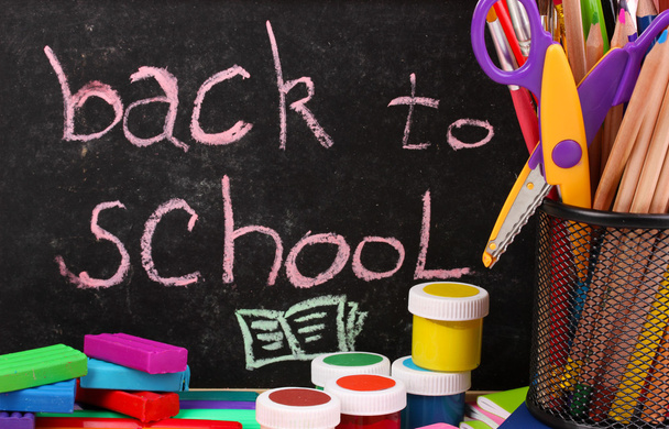 Słowa "Powrót do szkoły" napisane kredą na małej szkoły biurko z różnych szkół dostaw z bliska - Zdjęcie, obraz