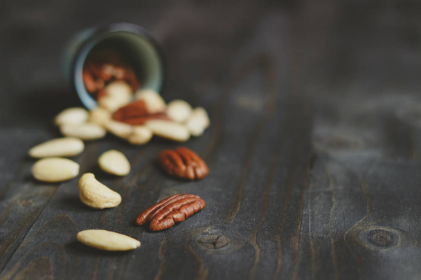 Nuts mix. Cashews, almonds and pecans on the wooden table, with copy space. Selective focus - Fotó, kép