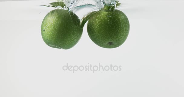 Granny Smith Apples, malus domestica, Fruits entering Water against White Background, Slow Motion 4K - Video