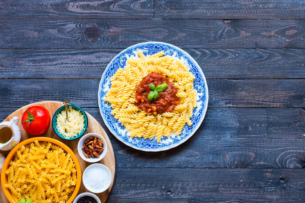 Fusilli pasta with tomato sauce, tomatoes, onion, garlic, dried  - Foto, immagini