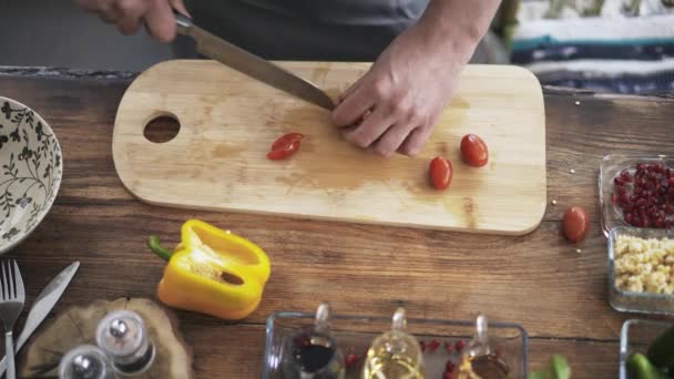 Pohled shora šéfkuchaře, krájení na plátky cherry rajčátka a jejich uvedení v misce - Záběry, video