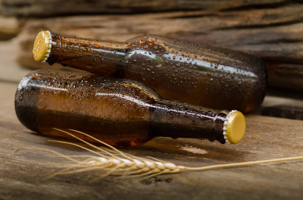 Láhev pivo na dřevěný stůl - Fotografie, Obrázek
