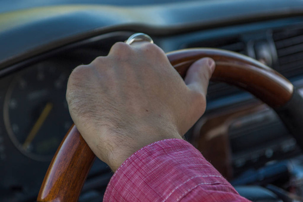 Man's hand on the steering wheel inside of a car - Foto, afbeelding