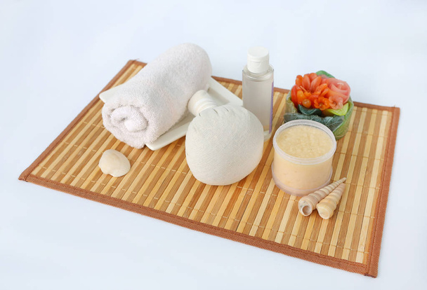 Spa herbal compressing ball with towels and Salt Scrub, Spa concept on bamboo weave mat against white background - Foto, afbeelding