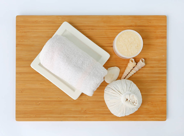 Spa herbal compressing ball with towels and Salt Scrub, Spa concept on bamboo board against white background - Фото, зображення