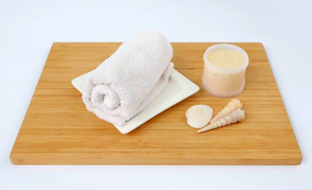 Spa concept, Towels and Salt Scrub on bamboo board against white background - Photo, image