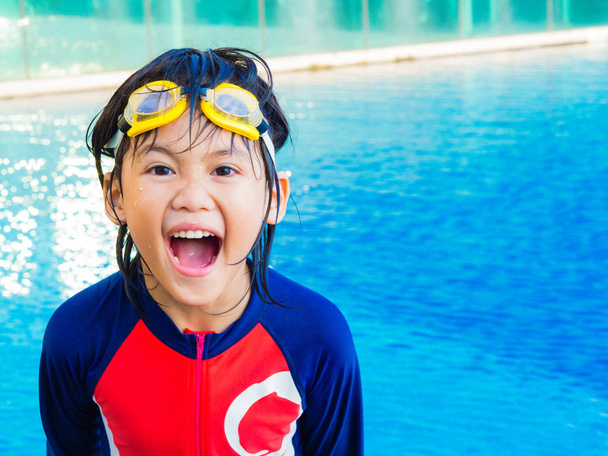 Mutlu küçük çocuk eğlenir ve yüzme havuzunda keyfini çıkarın - Fotoğraf, Görsel