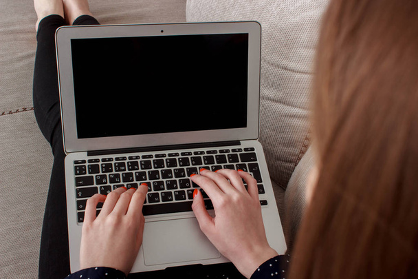 tyttö, jolla on älypuhelin ja älykellot, istuu kannettavassa tietokoneessa
 - Valokuva, kuva