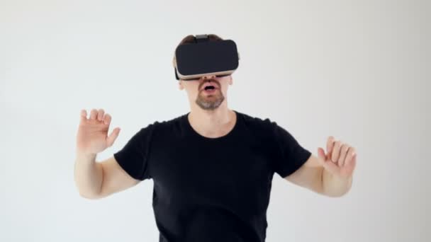 Een man is het dragen van virtual reality headset op zoek bang. Witte achtergrond. 4k. - Video