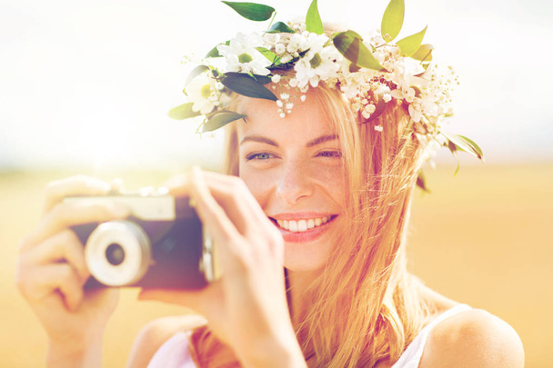 happy woman with film camera in wreath of flowers - Fotoğraf, Görsel