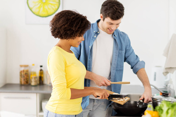 happy couple cooking food at home kitchen - Foto, imagen