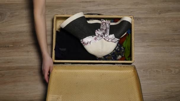 Hands put passport in suitcase. Map and passport on clothes. Season of vacation. Woman gets ready for flight - Video, Çekim