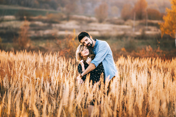 Homem abraçando mulher no campo de trigo
 - Foto, Imagem