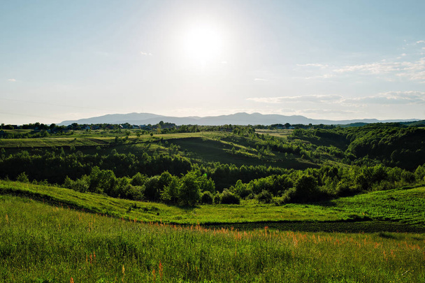 Красиві зелені пагорби на заході сонця
. - Фото, зображення