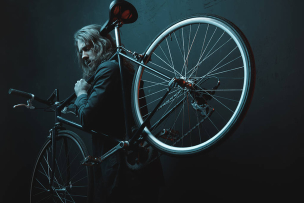 Fiatal férfi kerékpárral  - Fotó, kép