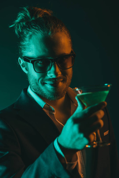 elegante hombre sosteniendo vaso con cóctel
 - Foto, imagen