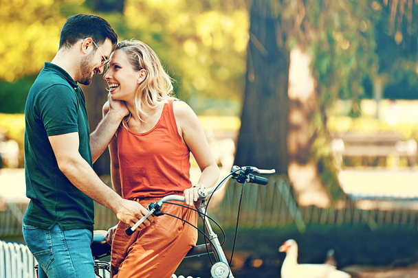 Happy Couple Riding a Bike - Фото, изображение