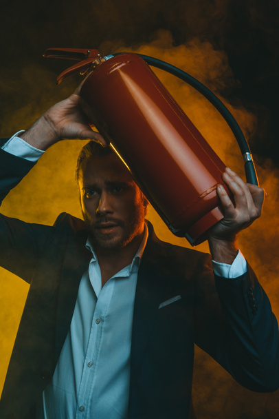 man in suit holding fire extinguisher - Photo, Image