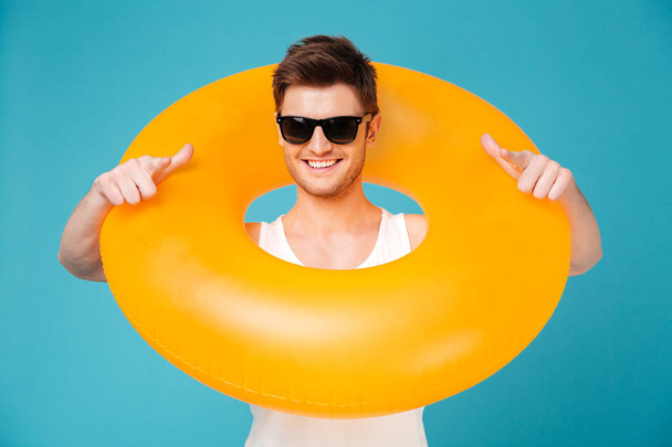 Guy in sunglasses holding inflatable ring aroung his neck - Foto, Bild