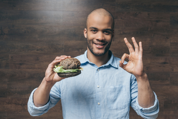 Young man with hamburger  - Zdjęcie, obraz