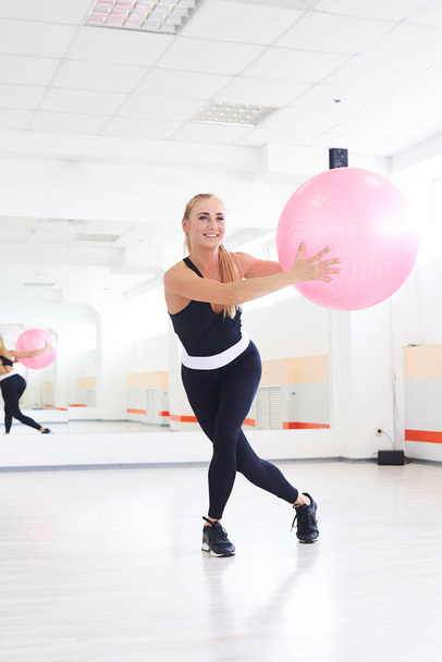 Young woman stretching with fitball at pilates workout  - Foto, afbeelding