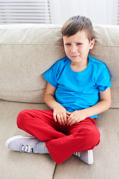 Υψηλή γωνία απογοητευμένοι αγόρι κλαίει στον καναπέ  - Φωτογραφία, εικόνα