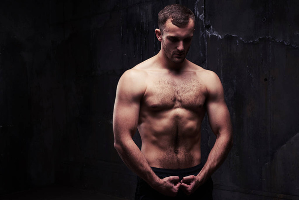 Shirtless man looking at his pumped biceps - Photo, Image