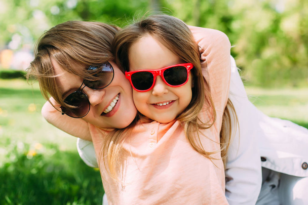 Summer. Portrait of mother with daughter having fun. Woman and girl child kid in sunglasses. - Photo, Image