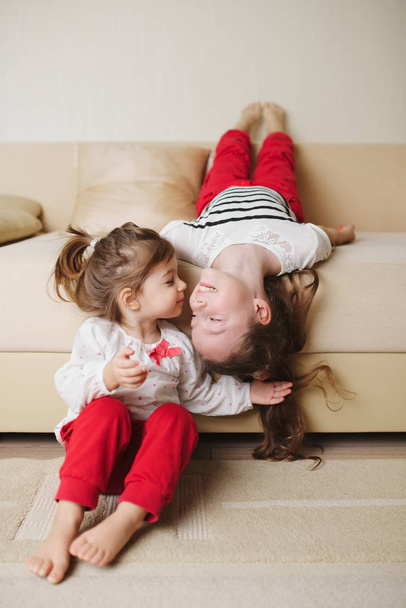 little cute girls on the couch upside down - 写真・画像