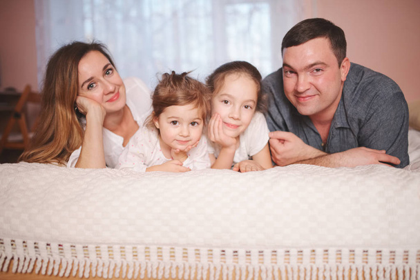 young family lying in bed at home - Photo, Image