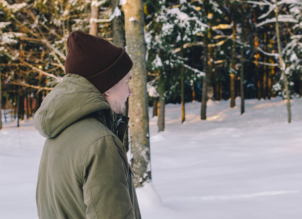 Young man in winter forest - Fotoğraf, Görsel