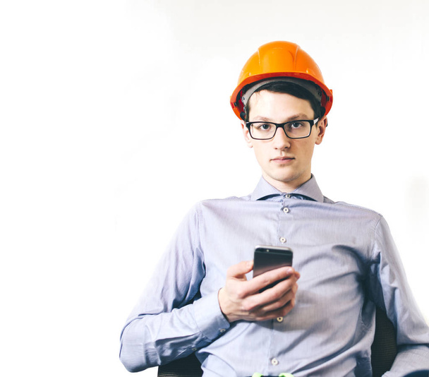 Engineer in a hardhat with phone - 写真・画像